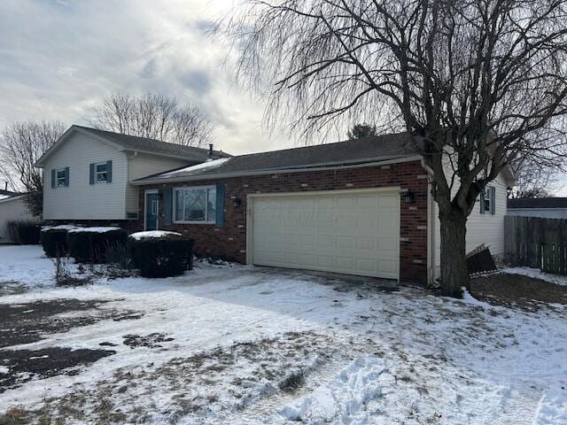 split level home with a garage and brick siding