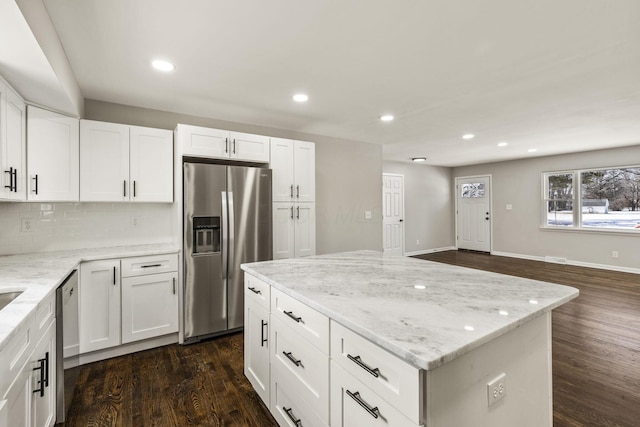 kitchen featuring light stone countertops, recessed lighting, appliances with stainless steel finishes, white cabinets, and dark wood-style flooring