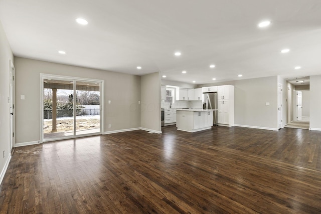 unfurnished living room featuring recessed lighting and dark wood finished floors