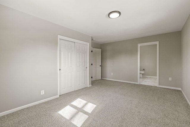 unfurnished bedroom with a closet, baseboards, and carpet