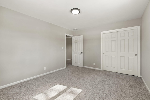 unfurnished bedroom featuring a closet, baseboards, and carpet flooring