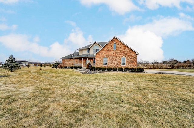 traditional-style home featuring a front lawn and brick siding