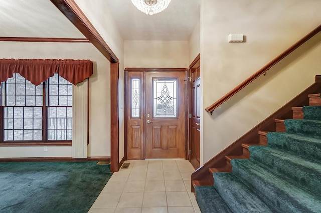 foyer featuring light tile patterned floors, plenty of natural light, stairway, and light colored carpet