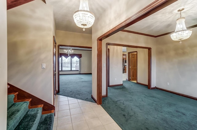 entryway featuring a chandelier, light tile patterned flooring, light colored carpet, baseboards, and crown molding