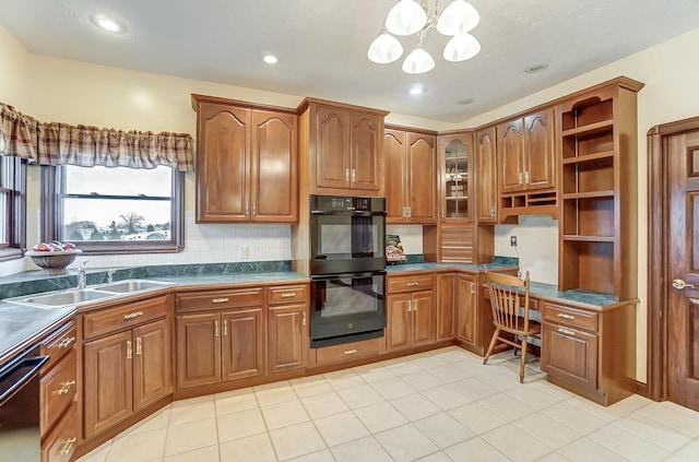 kitchen featuring dark countertops, built in desk, brown cabinets, and a sink