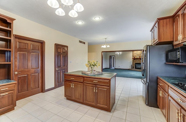 kitchen with a chandelier, black microwave, visible vents, dark countertops, and pendant lighting