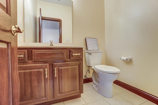 bathroom featuring baseboards, vanity, toilet, and tile patterned floors