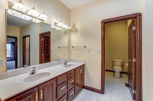 full bathroom with double vanity, tile patterned flooring, a sink, and toilet