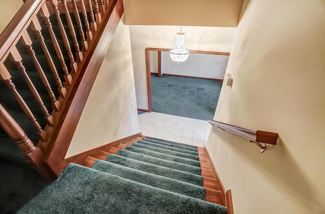 staircase with carpet, a notable chandelier, baseboards, and tile patterned floors