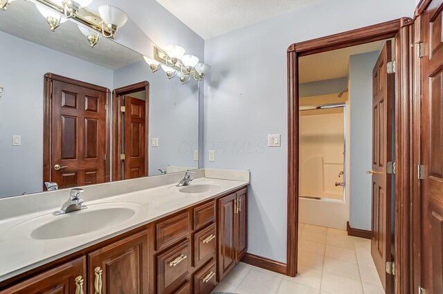 bathroom with double vanity, tile patterned floors, a sink, and an inviting chandelier