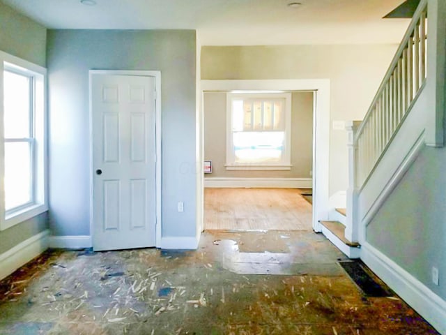 entrance foyer with baseboards, visible vents, and stairway