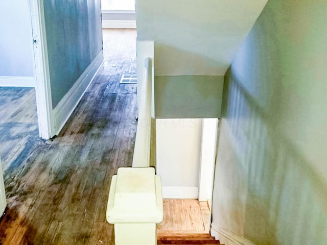 hall with dark wood-style flooring and baseboards