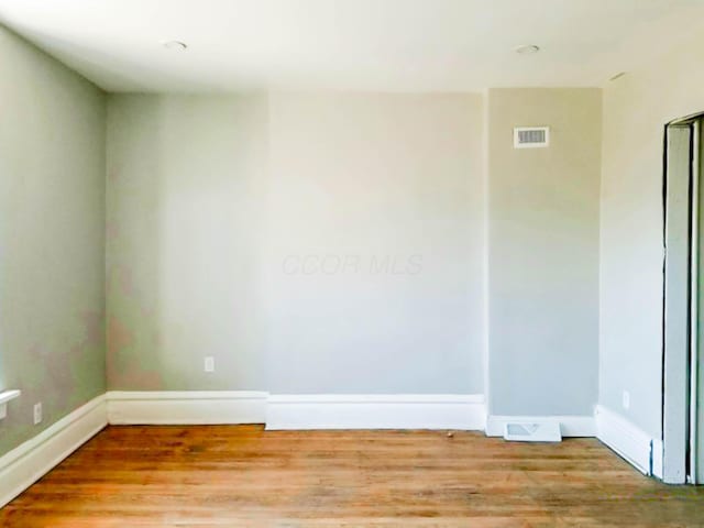 unfurnished room with light wood-style flooring, visible vents, and baseboards