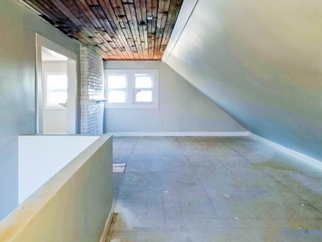 additional living space featuring vaulted ceiling and baseboards