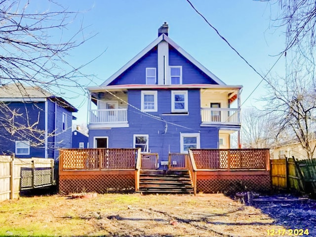 back of property featuring a chimney, fence, and a wooden deck