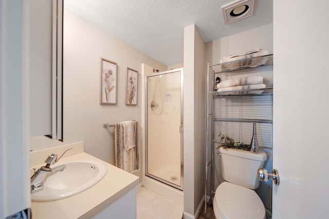 bathroom with toilet, a shower stall, a textured ceiling, and vanity