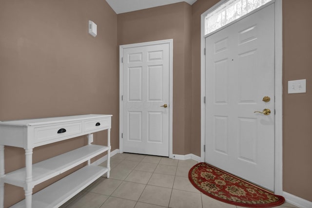 foyer featuring baseboards and light tile patterned floors