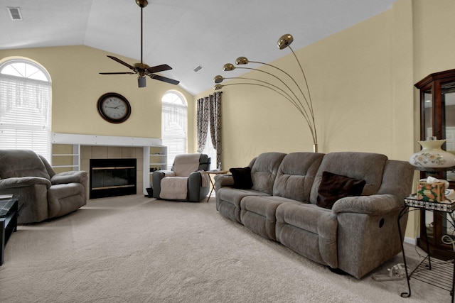 carpeted living room with high vaulted ceiling, visible vents, plenty of natural light, and a fireplace