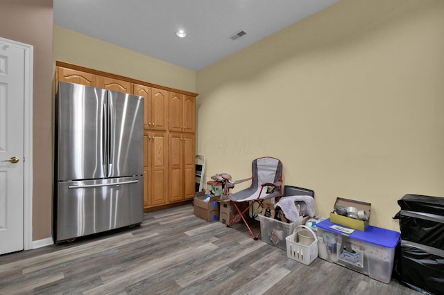 kitchen with visible vents, wood finished floors, and freestanding refrigerator