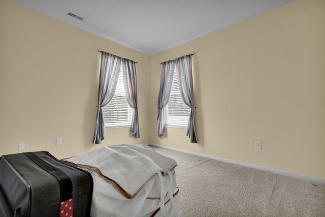 bedroom featuring light carpet, baseboards, and visible vents