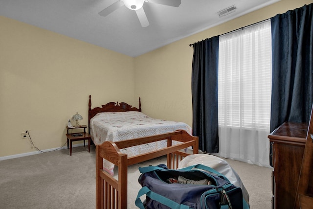 bedroom featuring light carpet, ceiling fan, visible vents, and baseboards