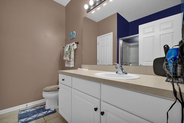 bathroom featuring a stall shower, baseboards, toilet, tile patterned flooring, and vanity