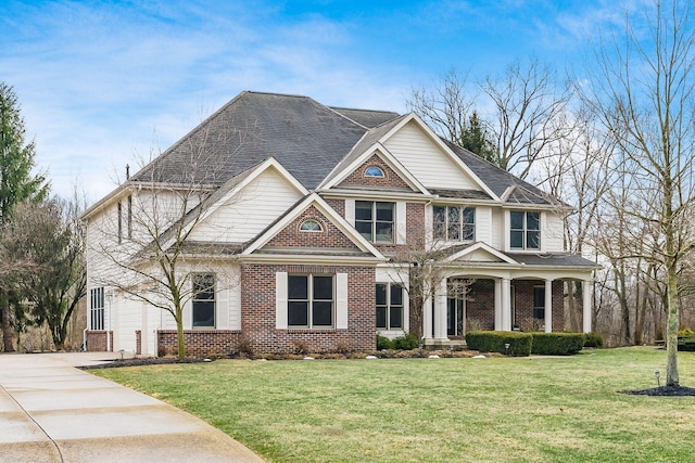 craftsman-style home with a garage, brick siding, concrete driveway, covered porch, and a front yard