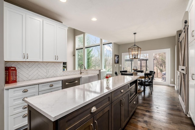 kitchen featuring a sink, white cabinets, appliances with stainless steel finishes, dark wood-style floors, and tasteful backsplash