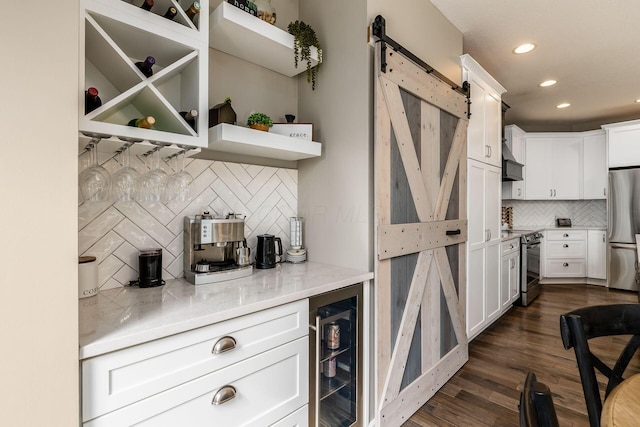 kitchen with a barn door, wine cooler, white cabinets, appliances with stainless steel finishes, and open shelves