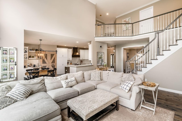 living area featuring crown molding, stairway, wood finished floors, a chandelier, and baseboards