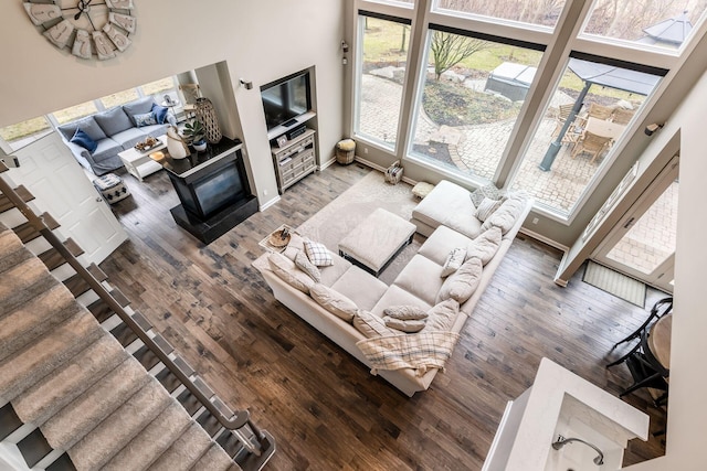 living area with a fireplace, wood finished floors, and baseboards