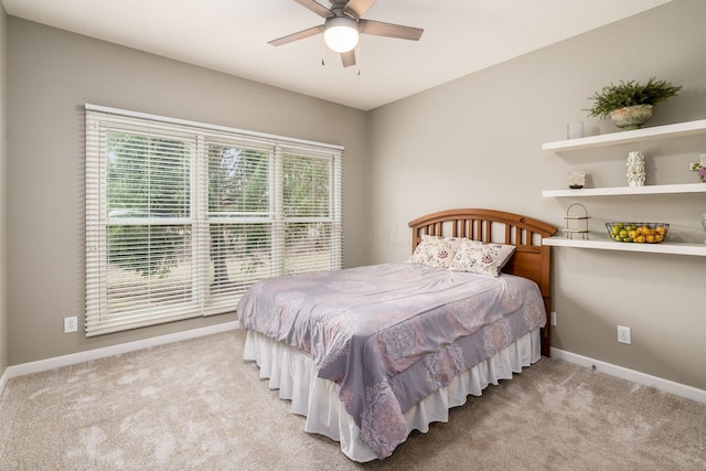 bedroom with a ceiling fan, light colored carpet, and baseboards