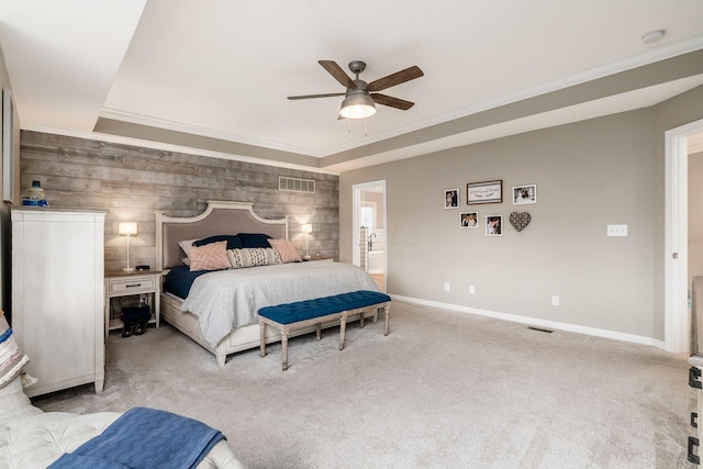 bedroom featuring carpet floors, an accent wall, baseboards, and crown molding