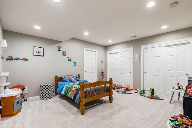 bedroom featuring recessed lighting, visible vents, baseboards, carpet, and two closets