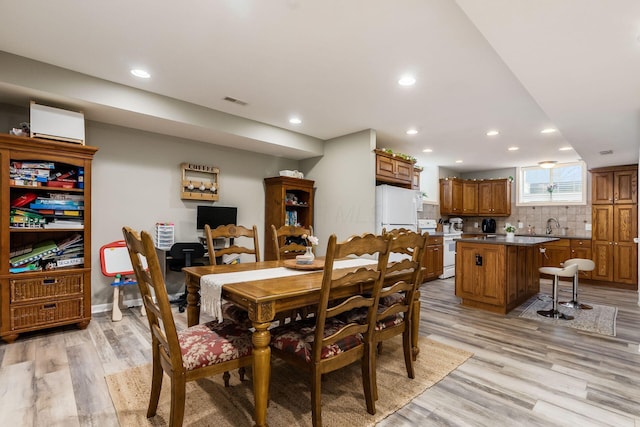 dining area featuring light wood-style flooring and recessed lighting