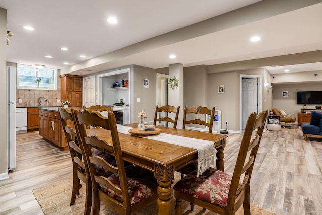 dining room featuring baseboards, light wood-style flooring, and recessed lighting