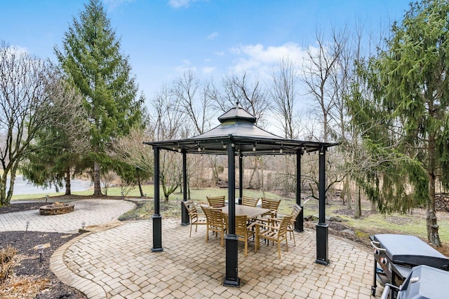 view of patio with an outdoor fire pit, outdoor dining space, and a gazebo