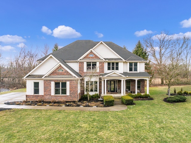 view of front of property featuring a porch, a front yard, and brick siding