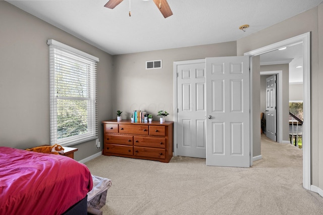 carpeted bedroom featuring baseboards, ceiling fan, and visible vents