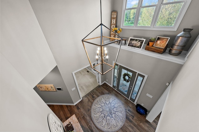 foyer entrance featuring an inviting chandelier, baseboards, and wood finished floors