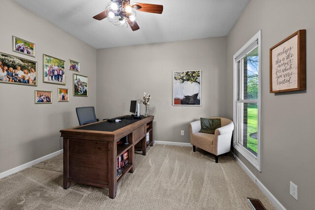 home office with carpet flooring, a ceiling fan, baseboards, and visible vents