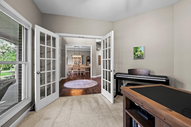 living area featuring french doors, carpet, and baseboards