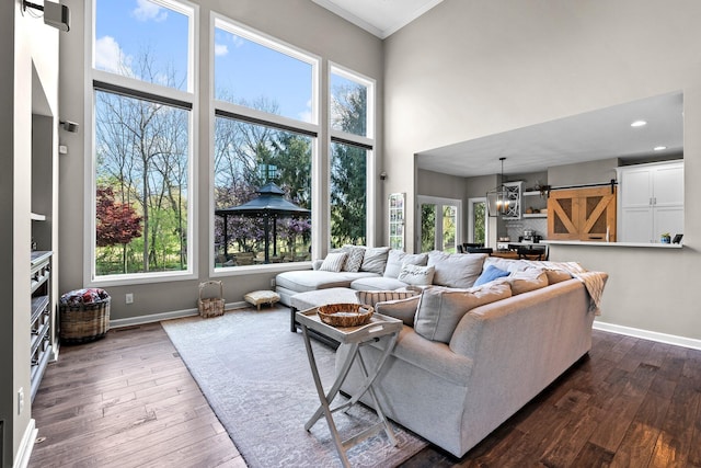 living room with crown molding, baseboards, and a healthy amount of sunlight