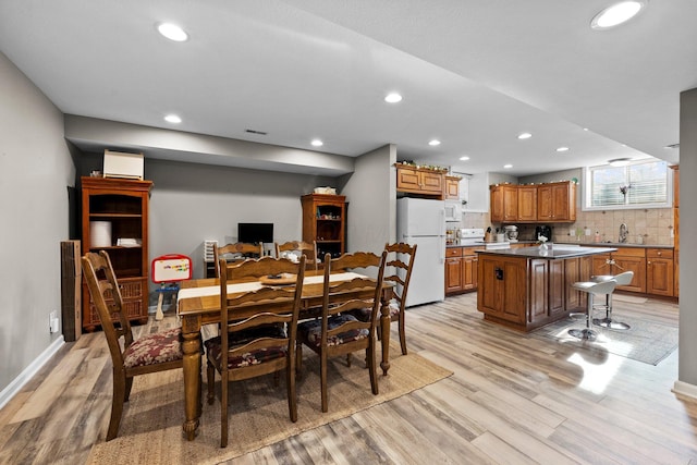 dining room featuring recessed lighting, light wood-style flooring, and baseboards