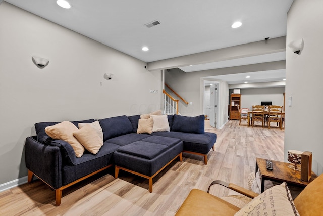 living room featuring recessed lighting, visible vents, light wood-style flooring, and stairway