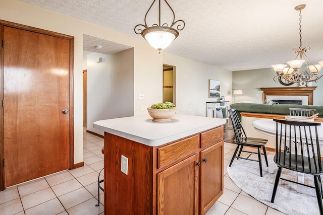 kitchen with a kitchen island, light countertops, a textured ceiling, and light tile patterned flooring