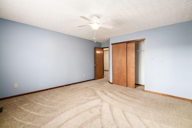 unfurnished bedroom featuring carpet, a closet, ceiling fan, a textured ceiling, and baseboards