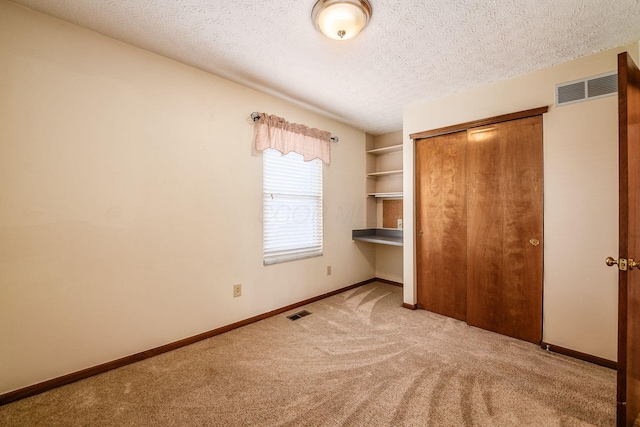 unfurnished bedroom featuring a textured ceiling, visible vents, and baseboards