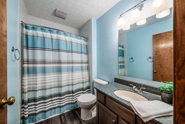 full bathroom with vanity, a textured ceiling, toilet, and wood finished floors