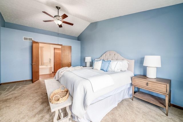 carpeted bedroom with lofted ceiling, baseboards, visible vents, and ensuite bathroom